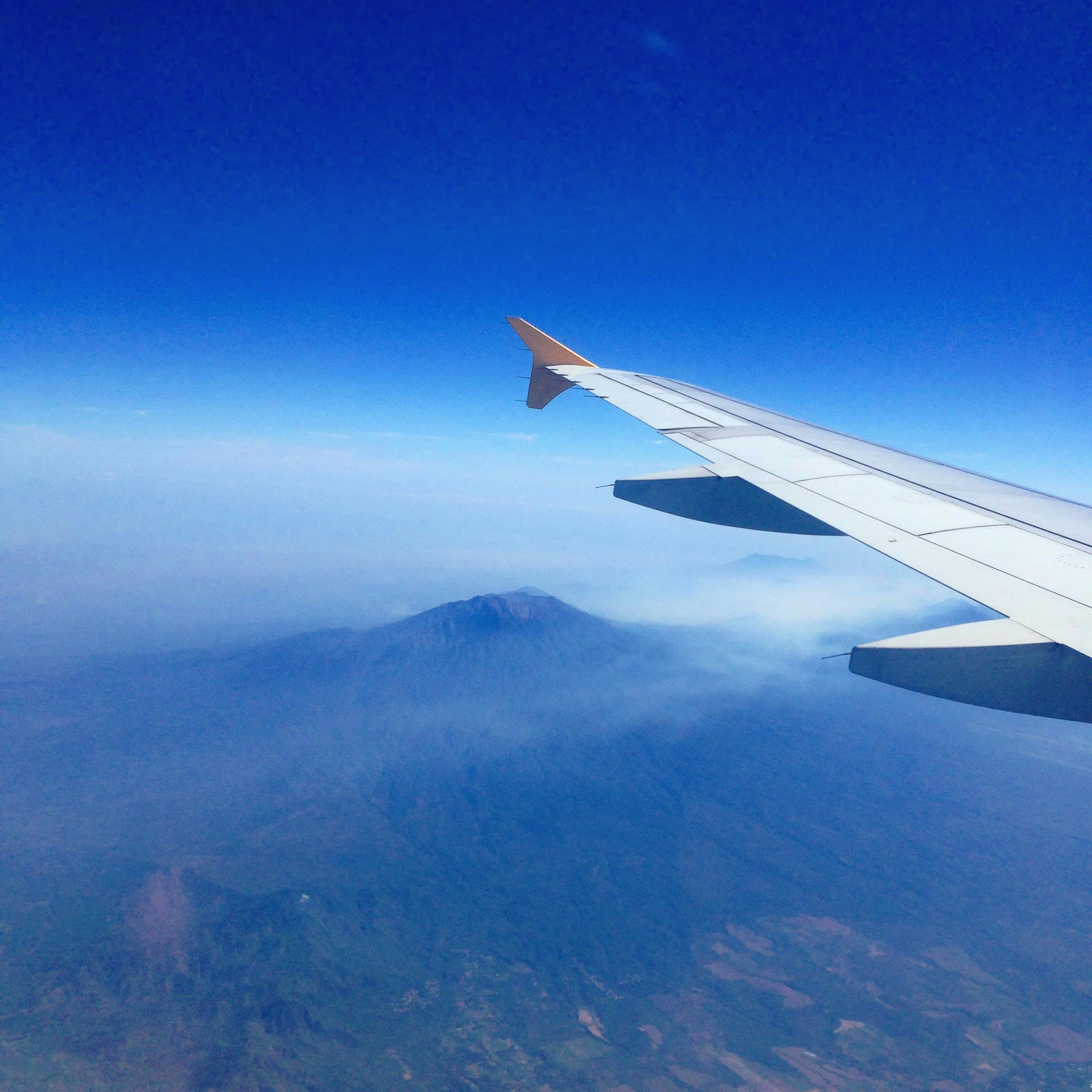A stunning aerial view of a mountain from an airplane window over Singapore.